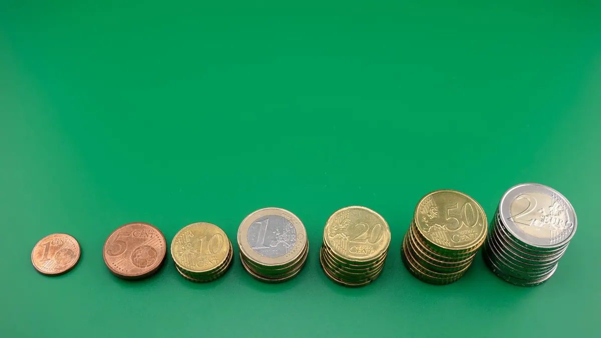 Oplopende stapels euromunten op een groene achtergrond, zoals bij een depositoladder