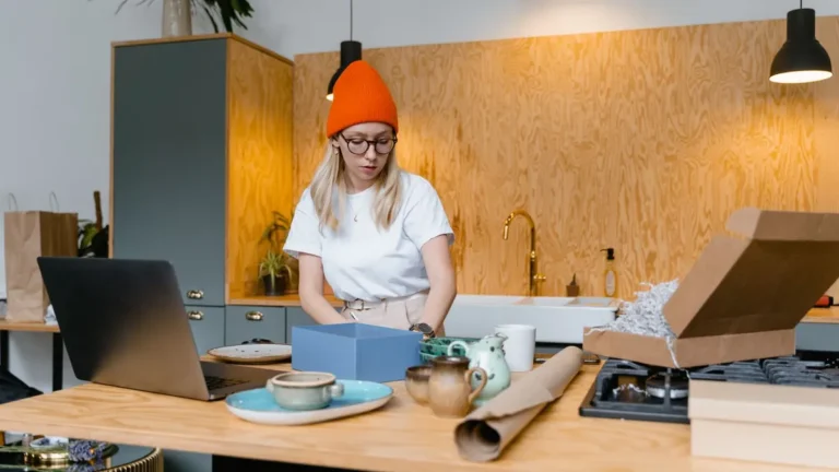 Vrouw pakt aan de keukentafel handgemaakte keramiek in voor haar side hustle